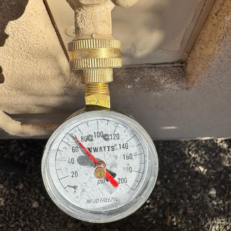 Pressure gauge on outdoor water line at meter box