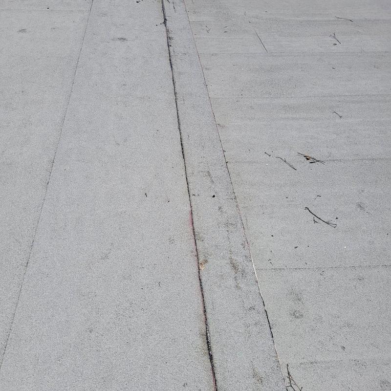 Modified bitumen flat roof seam with minor debris