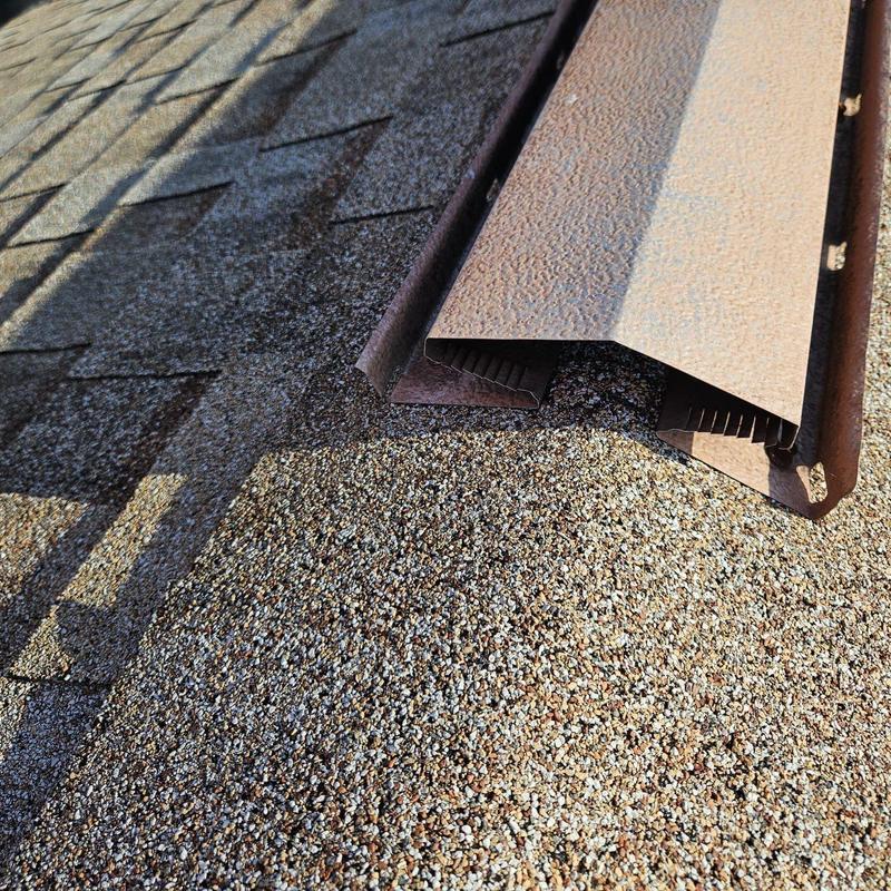 Asphalt shingle roof with metal ridge vent installation