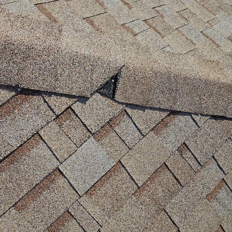 Shingle roof with damaged and misaligned shingles close-up