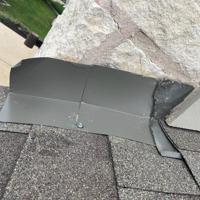 Kickout flashing installation on roof and stone wall