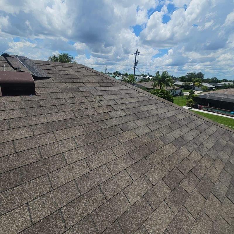 Brown asphalt shingle roof with repaired patch in Cape Coral