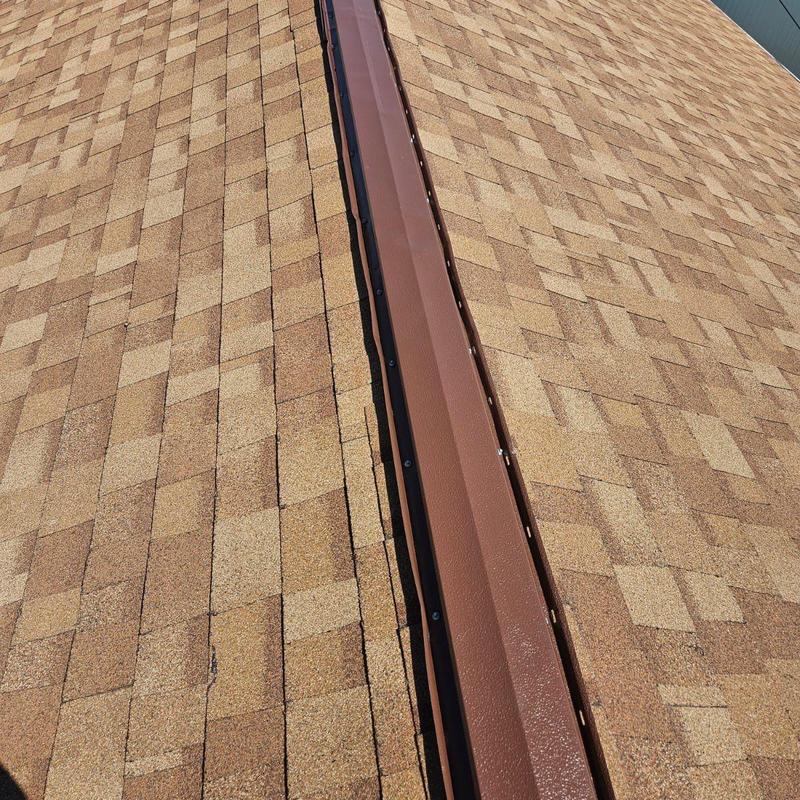 Shingle roof ridge cap with metal flashing installation