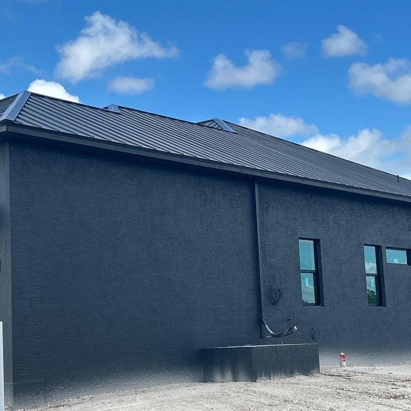 Standing seam metal roof on dark stucco house