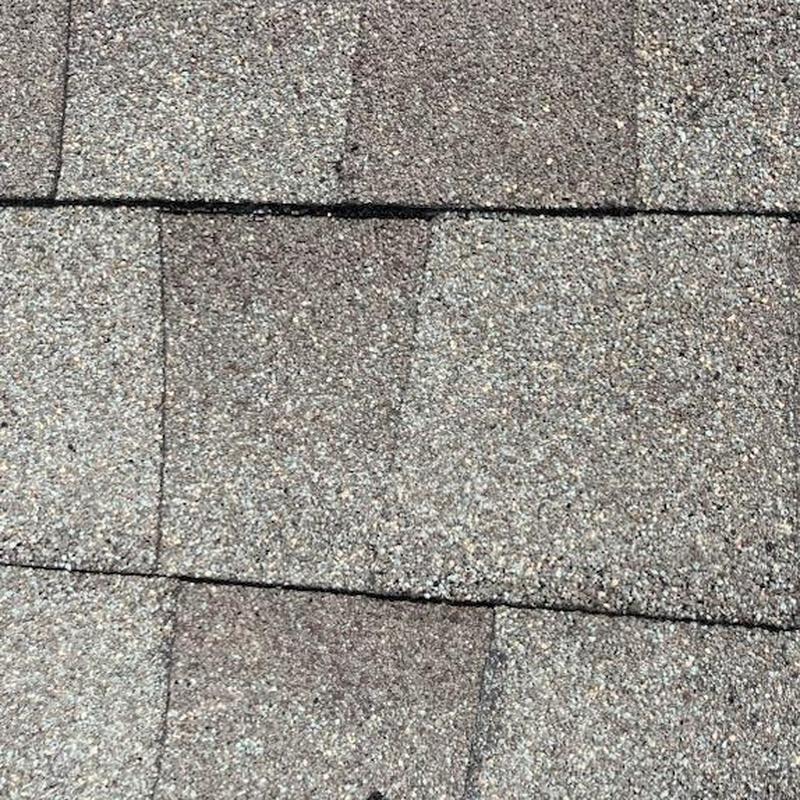 Roof shingles with bullet hole damage repair detail