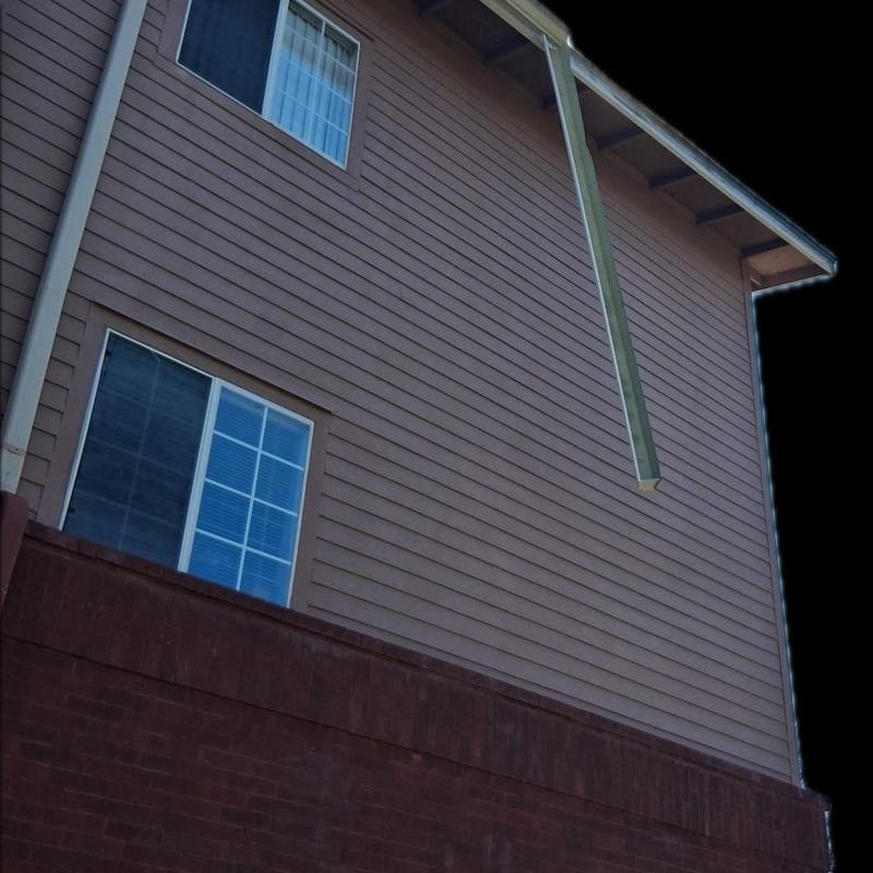 Gutter hanging from third-floor commercial building wall.