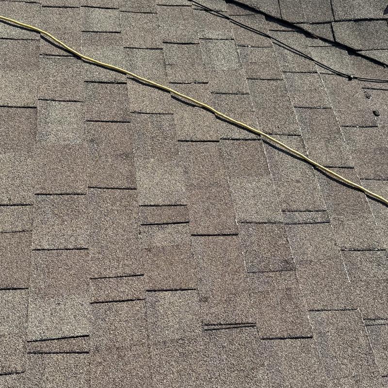 Asphalt roof shingles with visible wear and wiring