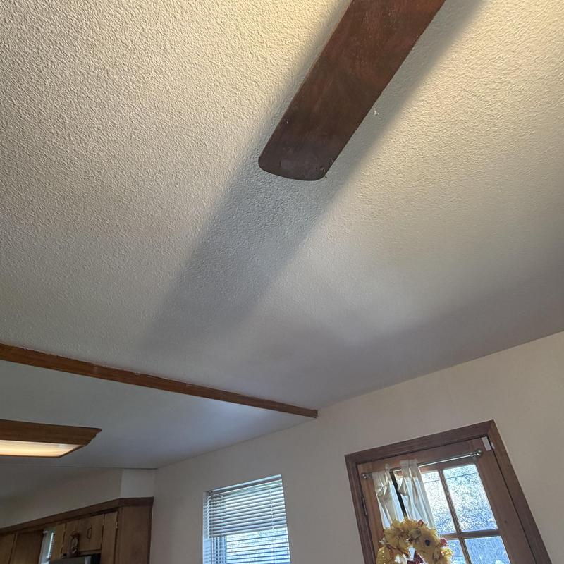 Sheetrock ceiling with textured finish and ceiling fan blade