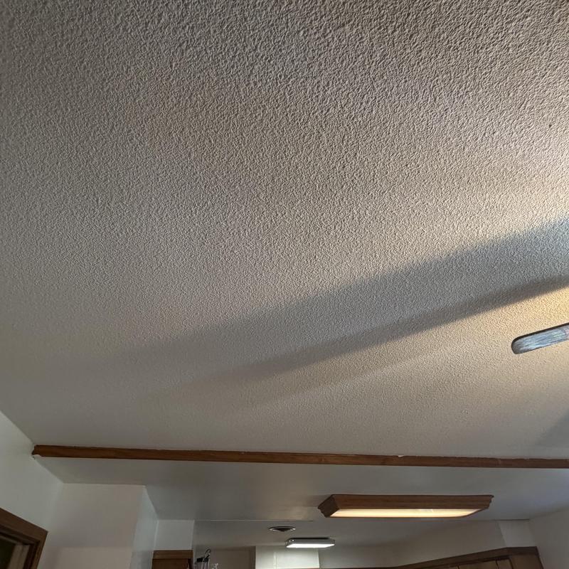 Textured kitchen ceiling with wood trim and lighting