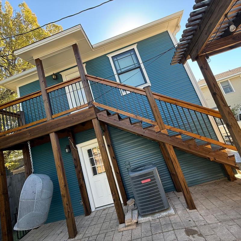 Wooden exterior stairs with railing and hanging chair