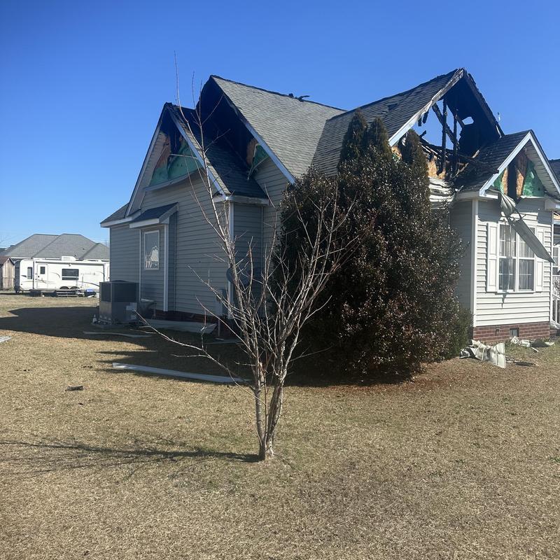 Roof sheathing and framing fire damage on house exterior Roof sheathing and framing fire damage on house exterior