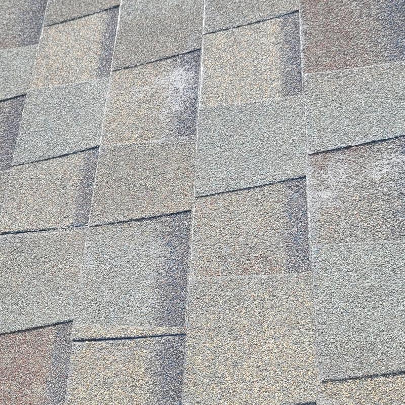 Asphalt roof shingles with hail damage close-up