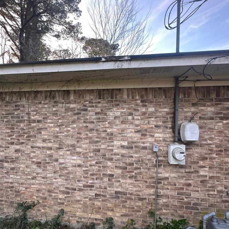 Roof edge and fascia inspection with brick wall background