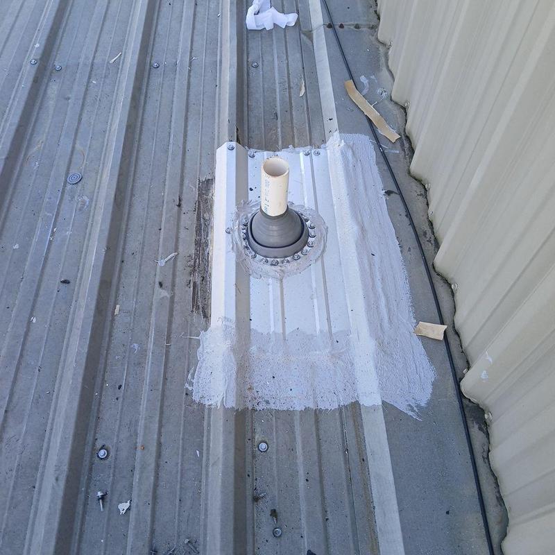 Metal roof pipe flashing with sealant on commercial roof