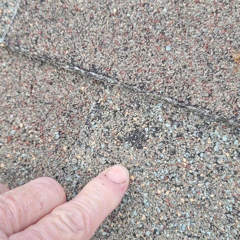 Asphalt roof shingle with hail storm damage close-up