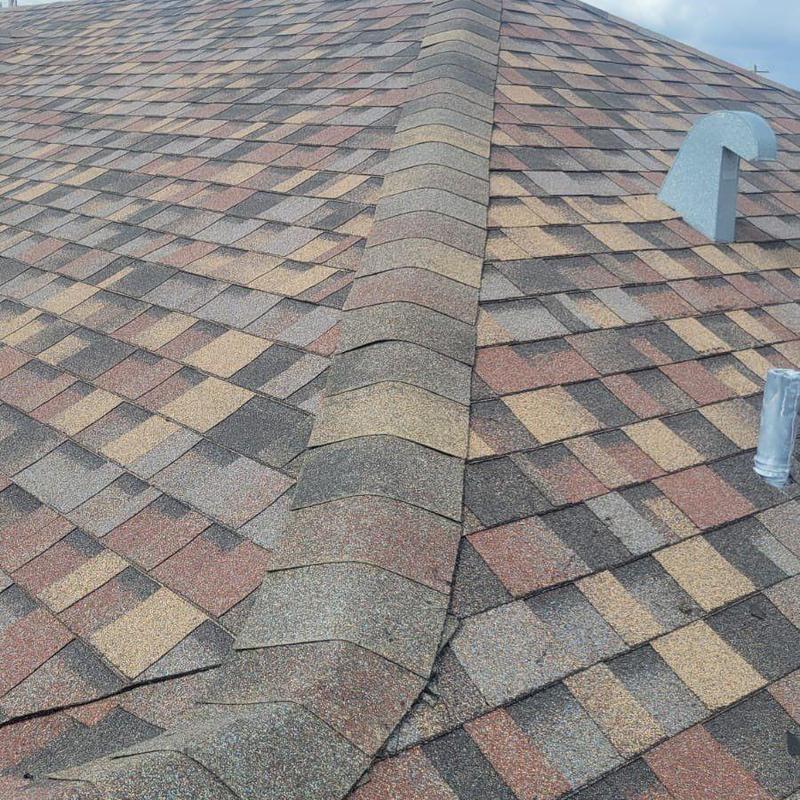 Shingle roof ridge with repaired asphalt shingles in Cape Coral