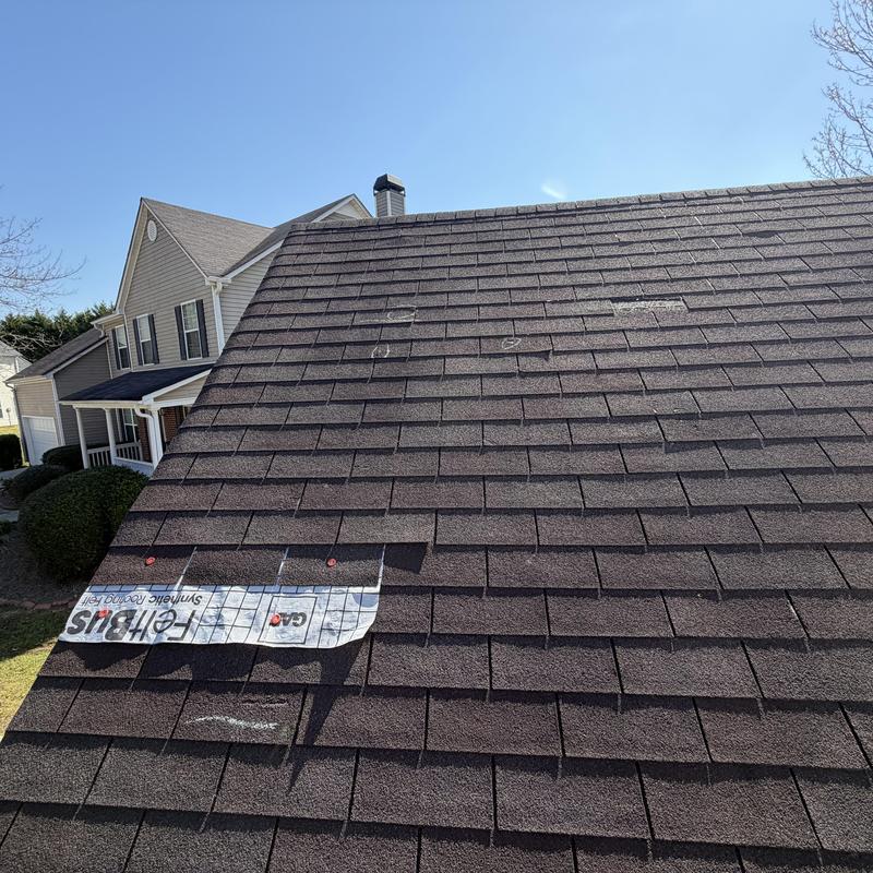 3-tab roof with damaged and missing shingles under tarp