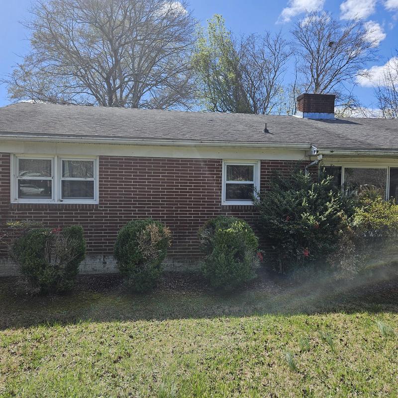 Brick siding exterior with trimmed shrubbery in front Brick siding exterior with trimmed shrubbery in front