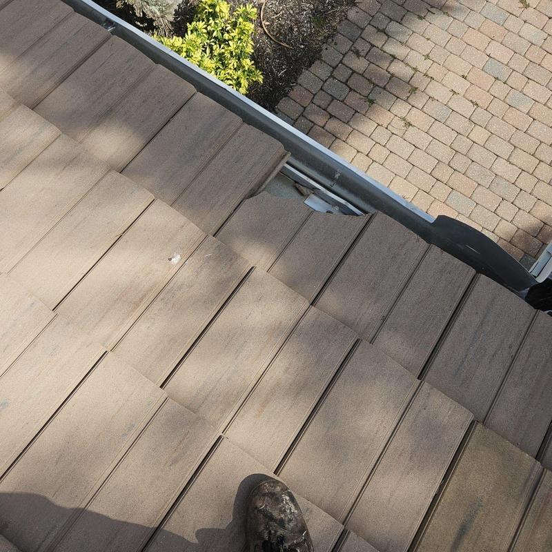 Concrete tile roof edge with damaged tile inspection