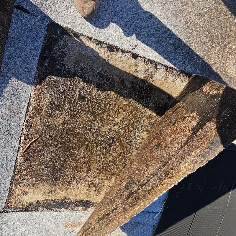 Damaged cap sheet on flat roof deck exposed