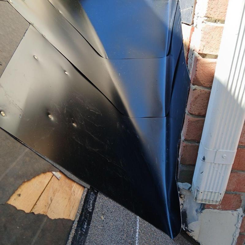 Dead valley pan installation on roof edge near brick wall