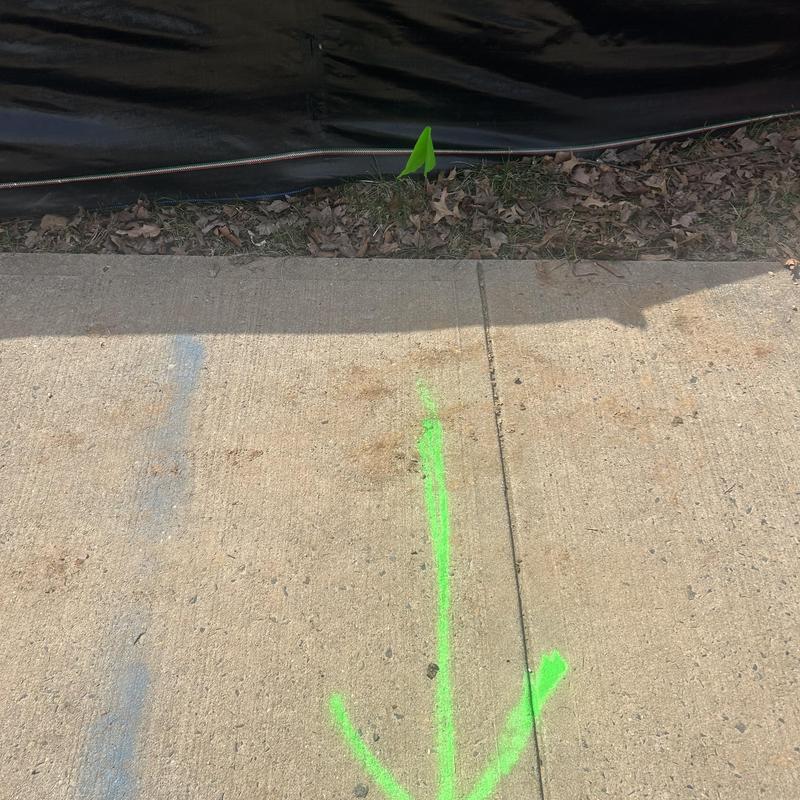 Concrete sidewalk with green spray paint arrow markings Concrete sidewalk with green spray paint arrow markings