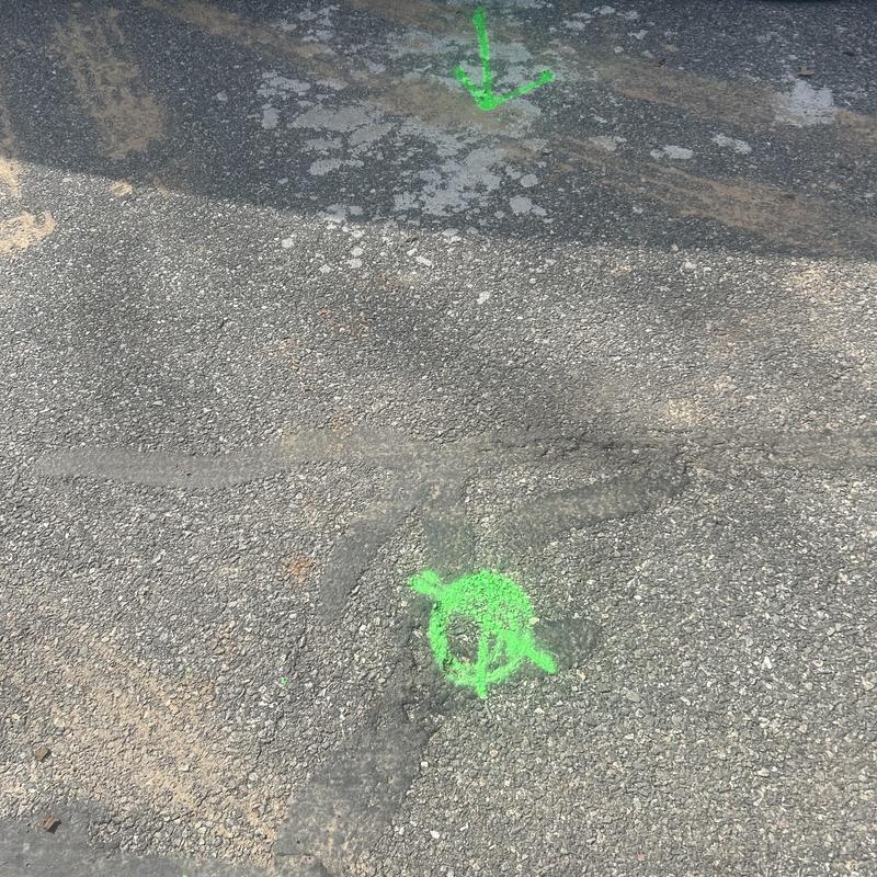 Sewer line access markings on asphalt surface Sewer line access markings on asphalt surface