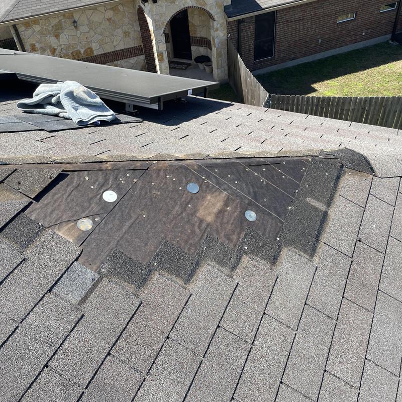 Roof shingles missing after wind damage on residential roof