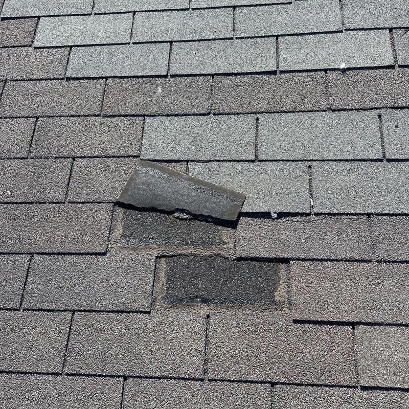 Asphalt roof shingles with missing and lifted tabs