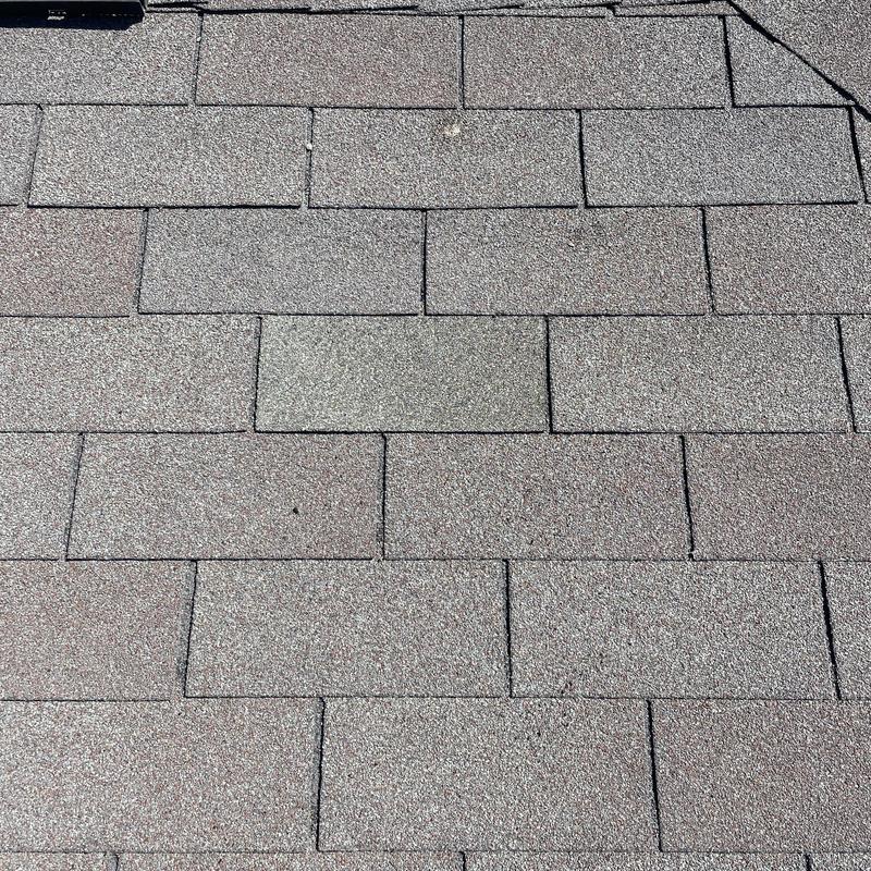 Asphalt shingle roof with replaced damaged shingles