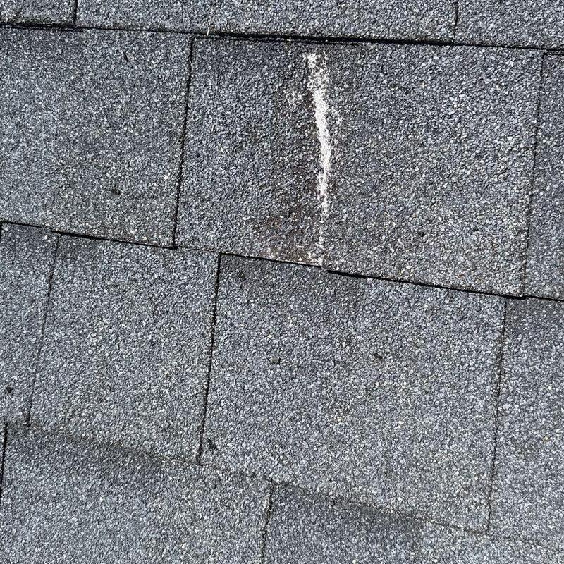 Asphalt roof shingles with hail damage and worn granules