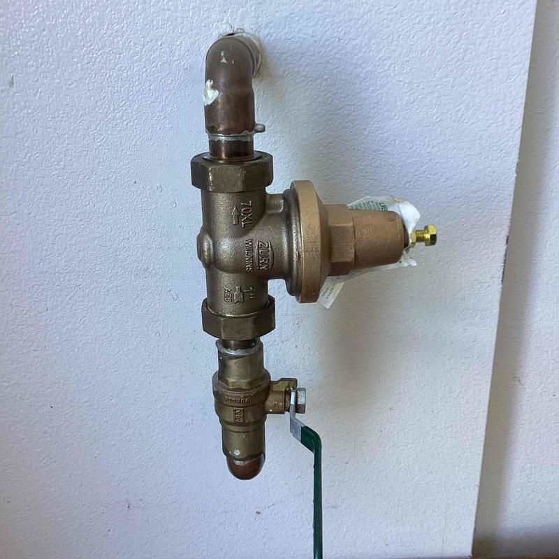 Zurn brass water pressure regulator installed on pipe