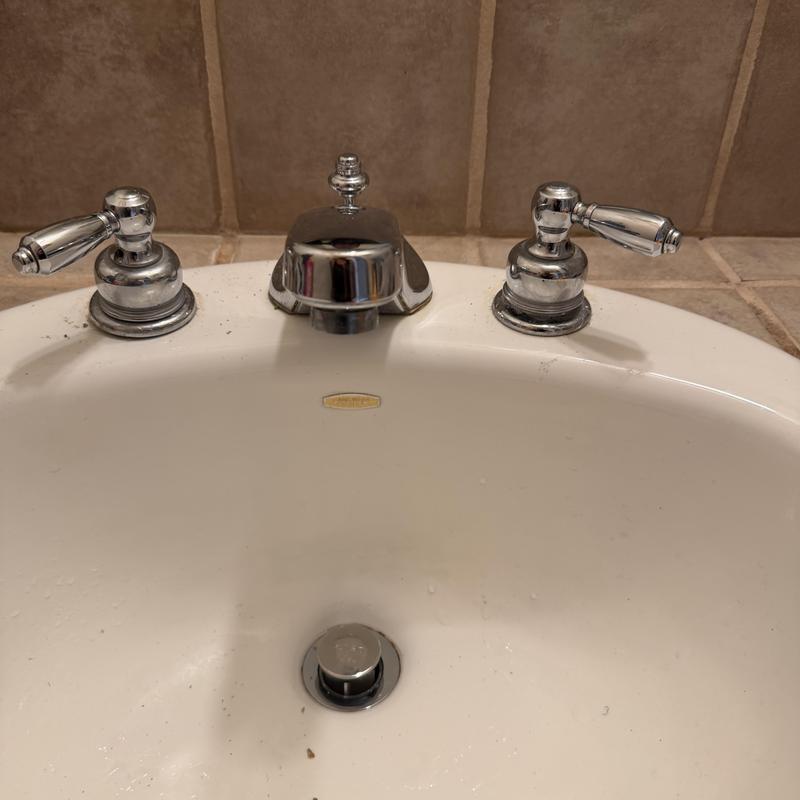 3-piece bathroom faucet on white sink with tile backsplash