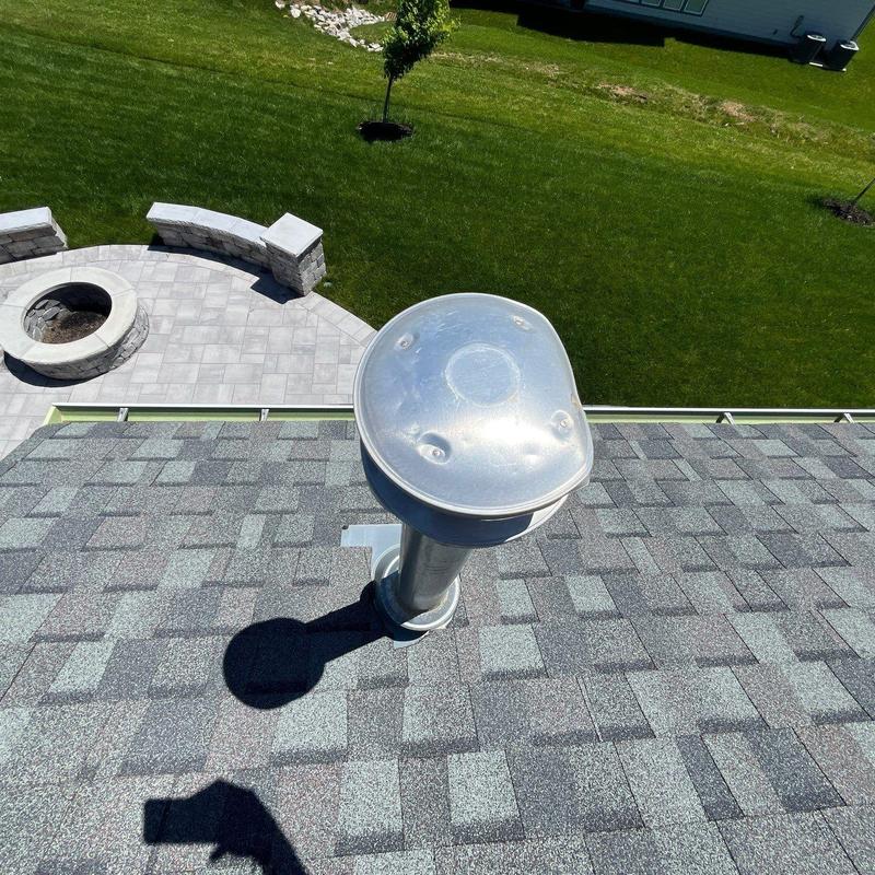 Roof vent pipe with hail damage on shingle roof