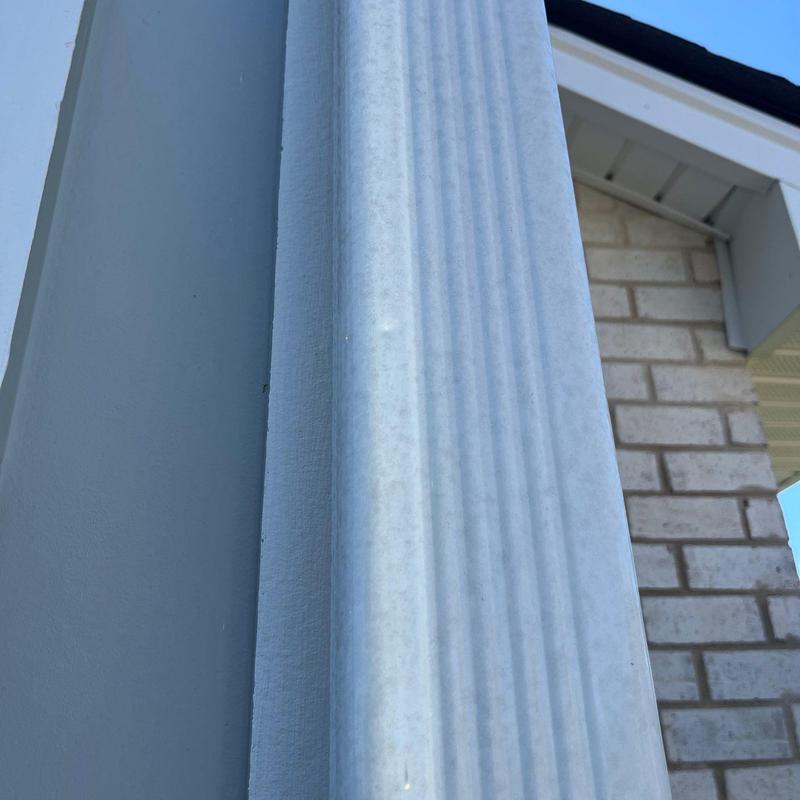 Vinyl column siding close-up with outdoor brick wall
