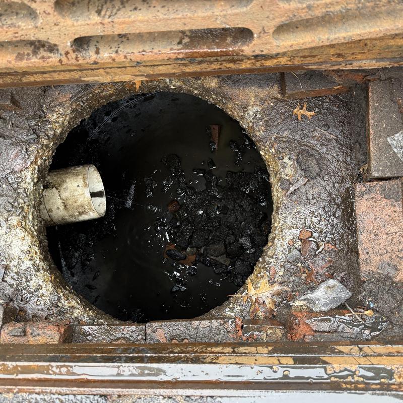 Storm basin interior with sediment buildup and pipe outlet Storm basin interior with sediment buildup and pipe outlet