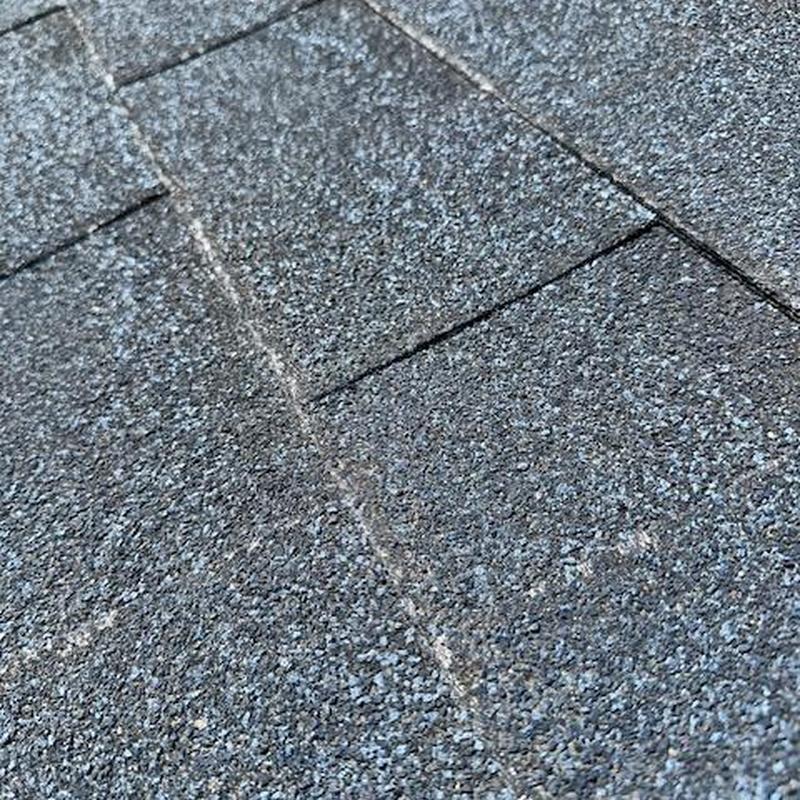 Asphalt shingle roof with visible wear and damage