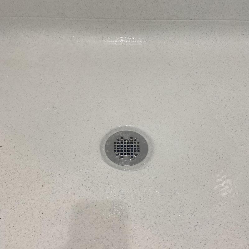 Shower drain replacement in white textured shower base