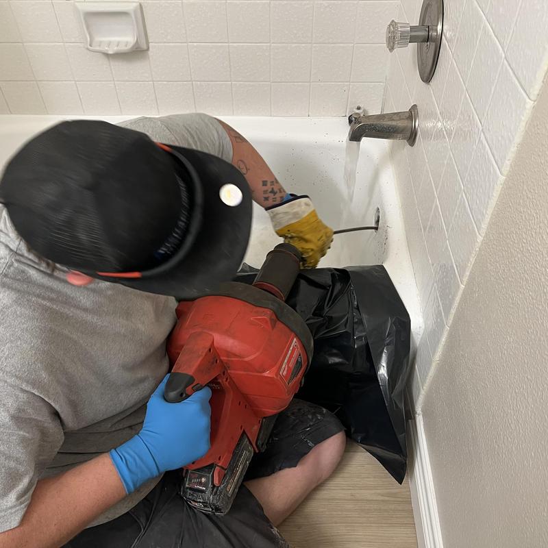 Tub drain roto rooter clearing hair clog in bathroom tub