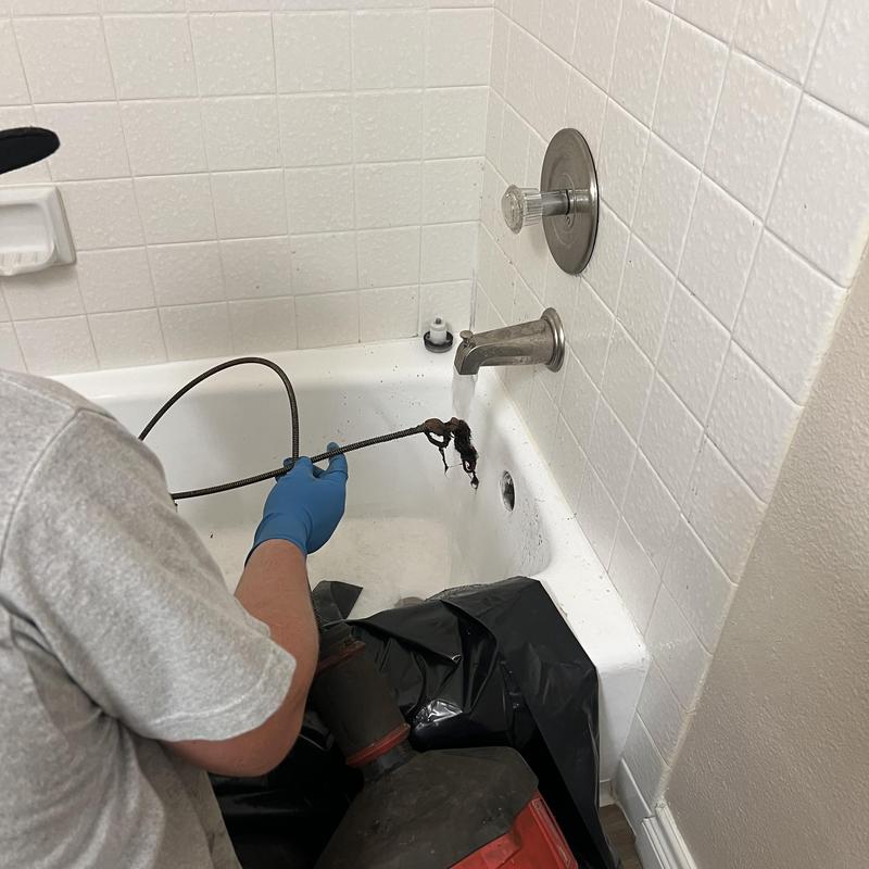 Tub drain roto-rooter clearing hair clog in bathroom tub