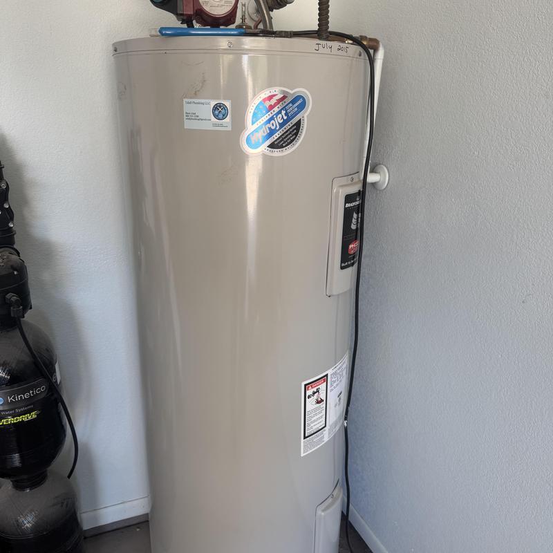 Electric water heater installation with plumbing connections