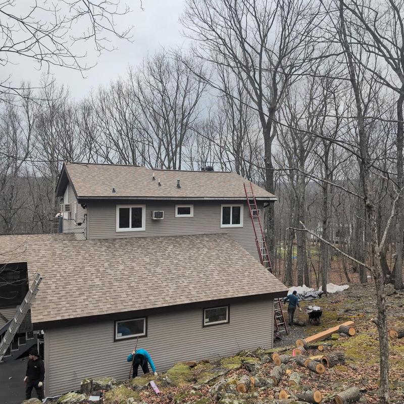 Asphalt shingle roof on house with ladder and workers Asphalt shingle roof on house with ladder and workers