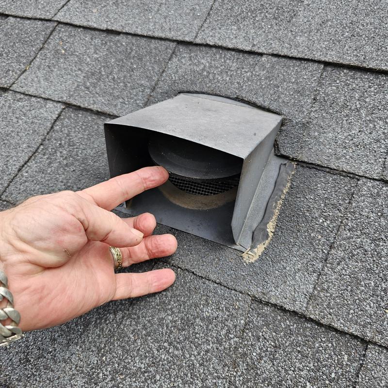 Roof vent cover with hail damage on asphalt shingles