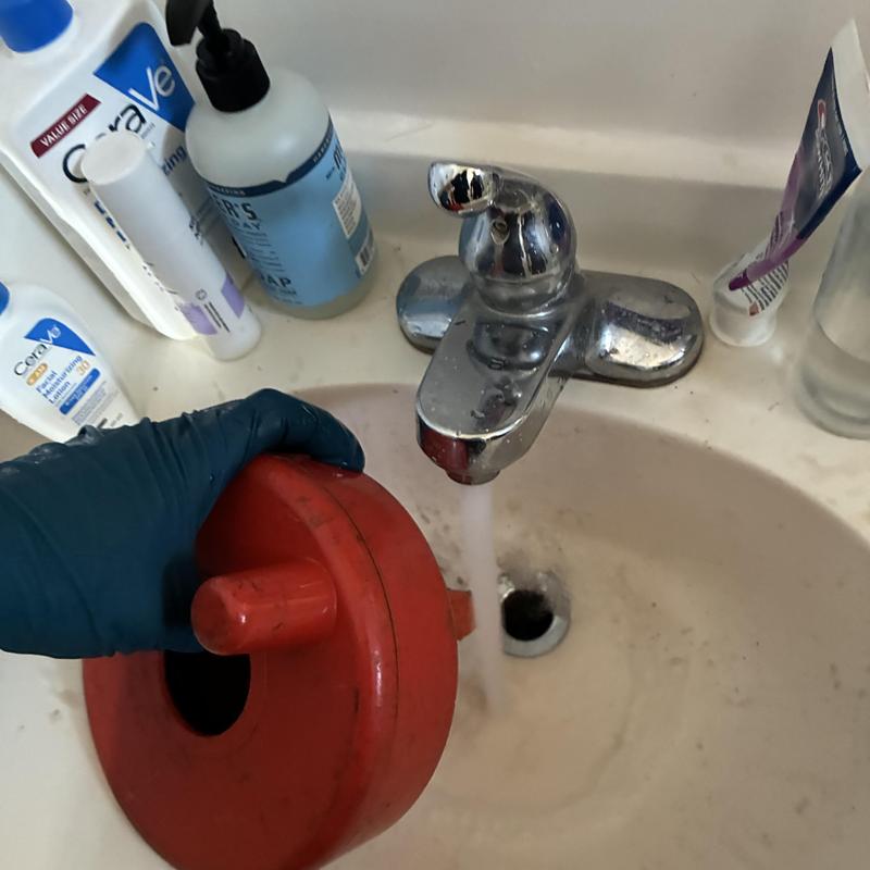 Basin drain with plumber tool clearing clog