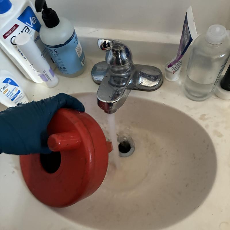 Basin drain clearing with plunger in residence sink