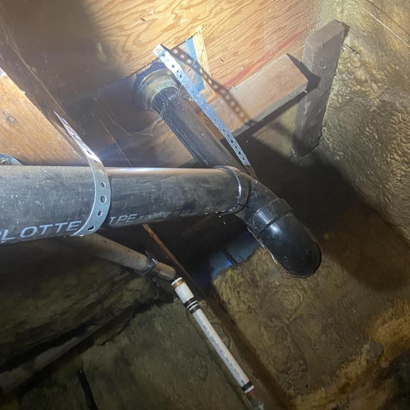 Shower drain pipes with new brackets in basement ceiling