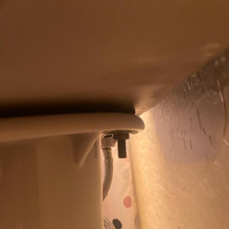 Toilet tank installation with mounting bolt and hose Toilet tank installation with mounting bolt and hose