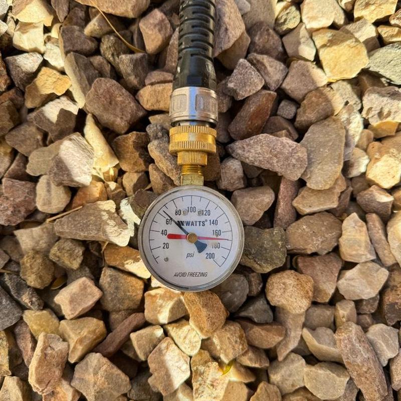 Pressure gauge on irrigation hose measuring PSI