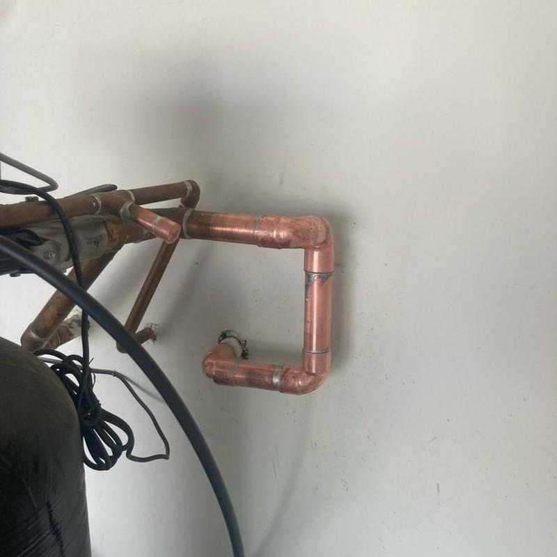Copper water softener piping installation on wall