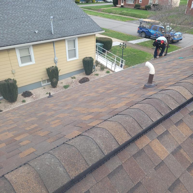 Asphalt shingle roof installation with ridge vent and pipe flashing